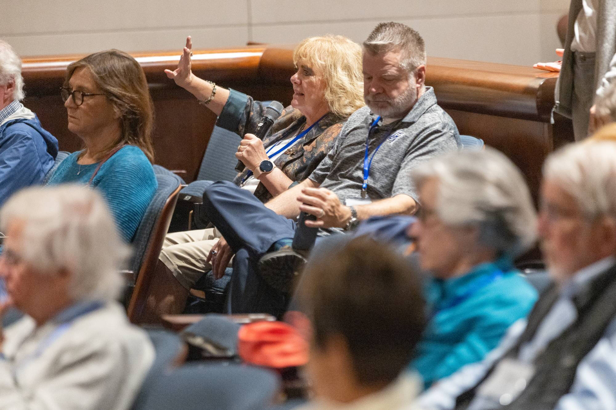 A Grand Forum attendee asks a question during a session.